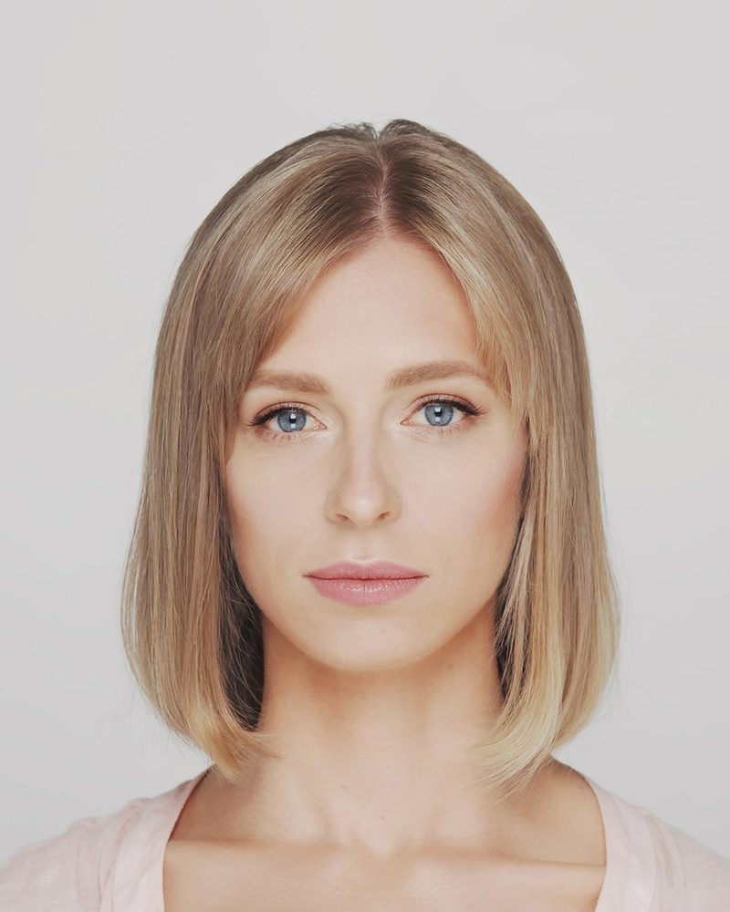Woman with a sleek, shoulder-length blonde bob and a center part.