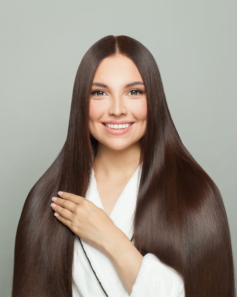 Smiling woman with very long, straight, glossy dark-brown hair.
